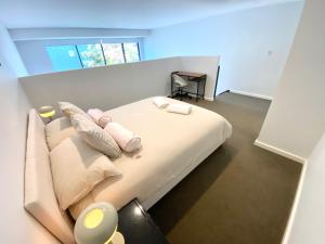 una camera con un letto con due cuscini sopra di Loft Style 1 bedroom Apartment a Sydney