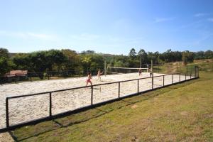 een groep kinderen die voetballen op een volleybalveld bij Limoeiro da Concórdia Hotel Fazenda de Charme in Itu