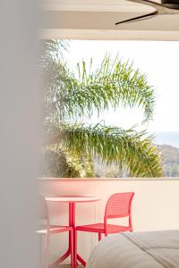 - une chambre avec deux chaises, une table et un palmier dans l'établissement Hillcrest Merimbula, à Merimbula