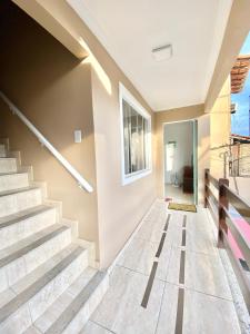 um corredor com escadas numa casa em Apartamento Apês do Peró 10 - centro - 5 pessoas em Cabo Frio