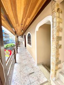 um corredor de uma casa com tecto de madeira em Apartamento Apês do Peró 10 - centro - 5 pessoas em Cabo Frio