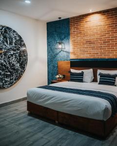 een slaapkamer met een groot bed en een bakstenen muur bij Hotel Casa Puga in Oaxaca City