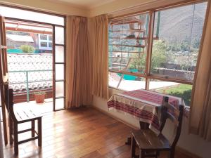 a room with a bed and a large window at Casa Saywa in Urubamba