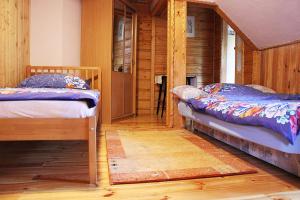 a room with two beds in a log cabin at Gościniec Saba in Zieleniec