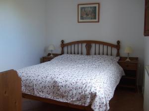 a bedroom with a bed and two night stands with lamps at Casa Pineda in Perelló