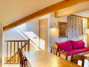 a living room with a red couch and a table at Charmant duplex 6 pers au cœur du village avec piscine et parking - FR-1-505-192 in Notre-Dame-de-Bellecombe