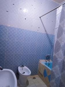 La salle de bains est pourvue de carrelage bleu, de toilettes et d'un lavabo. dans l'établissement Hostel Gueliz Marrakech, à Marrakech