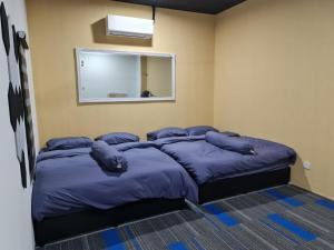 a bedroom with a large bed with blue pillows at Ayden Hostel Airport Transit - KLIA in Sepang