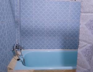 La salle de bains est pourvue d'une baignoire bleue et de carrelage bleu. dans l'établissement Hostel Gueliz Marrakech, à Marrakech