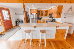 a kitchen with a counter and two stools at Pacific City River House Loft in Pacific City