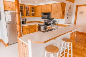 a kitchen with wooden cabinets and a stainless steel refrigerator at Pacific City River House Loft in Pacific City +10 photos