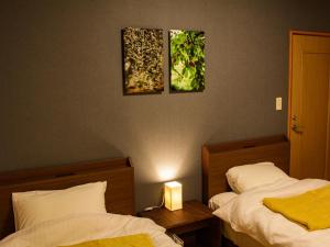 2 camas en una habitación con 2 lámparas y 2 cuadros en la pared en 1組限定　1棟貸切 「おとまり忠左衛門」　 グループや3世代旅行に最適　　　　, en Ikeda
