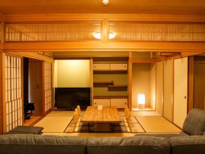 sala de estar con sofá y mesa en 1組限定　1棟貸切 「おとまり忠左衛門」　 グループや3世代旅行に最適　　　　 en Ikeda