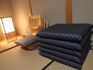 una pila de mantas en una habitación con lámpara en 1組限定　1棟貸切 「おとまり忠左衛門」　 グループや3世代旅行に最適　　　　 en Ikeda