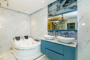 a bathroom with two sinks and a tub and a bath tub at Baku Sea View 3 bedroom in Baku