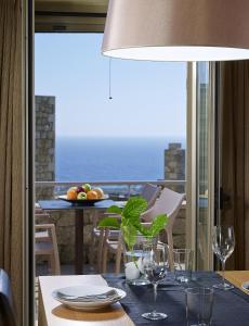 RigliaにあるAnaxo Resortのワイングラス付きのテーブル、バルコニー付きのテーブル