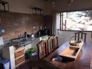 a kitchen with a sink and a wooden table at PORTAL DE LA OVEJERIA in Tafí del Valle