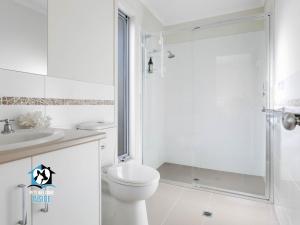 维克多港Light Filled Modern & Stylish 3BR Holiday Home的带马桶和淋浴的白色浴室 更多8张照片