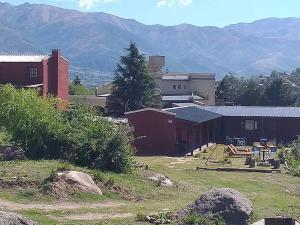 un groupe de bâtiments avec des montagnes en arrière-plan dans l'établissement PORTAL DE LA OVEJERIA, à Tafí del Valle