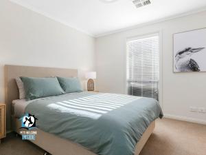 维克多港Light Filled Modern & Stylish 3BR Holiday Home的带床和窗户的卧室