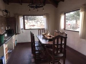 una cucina con tavolo e sedie in una stanza di PORTAL DE LA OVEJERIA a Tafí del Valle