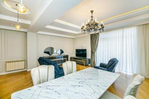 a dining room with a table and chairs and a television at Baku Sea View 3 bedroom in Baku