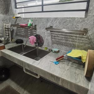 un comptoir de cuisine avec un évier et des outils dessus dans l'établissement 1号房有厕所厨房冰箱洗衣机, à Kuala Lumpur