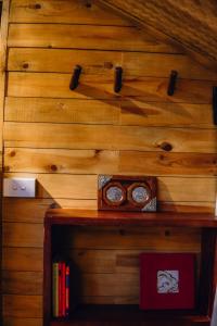 una parete di legno con due orologi e un libro di TALACÀ Homestay a Sa Pa