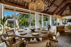 a dining room with a wooden table and chairs at Villa Gian Minima by BaliSuperHost in Ubud