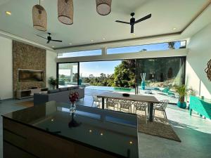 sala de estar con mesa y vistas a la piscina en VILLA CHLOE - SEAVIEW - 4 Bedrooms, en Koh Samui 