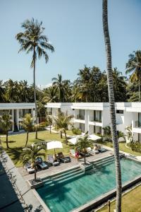 uma vista aérea de um resort com uma piscina e palmeiras em Sikara Lombok Hotel em Kuta Lombok