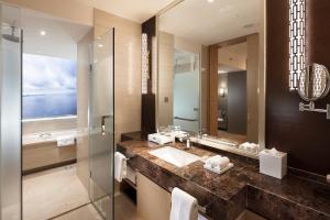 uma casa de banho com um lavatório e um espelho em Hilton Yantai em Yantai