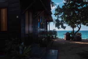 a house on the beach next to the ocean at Swiss Cottage Tioman in Tioman Island