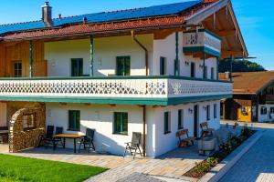 a house with a balcony and a patio at Ferienwohnungen Heillinger Gütl in Ruhpolding