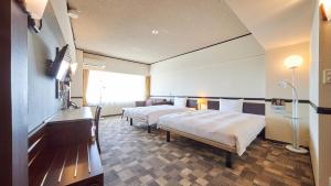ein Hotelzimmer mit 2 Betten und einem Fenster in der Unterkunft Toyoko Inn Narita Airport Honkan in Narita