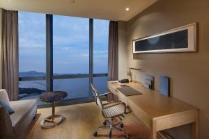 an office with a desk with a computer and a chair at Hilton Yantai in Yantai