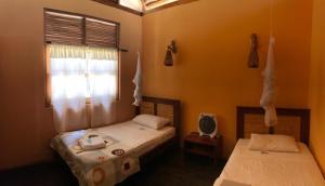 twee eenpersoonsbedden in een kamer met een raam bij Kites Mancora in Máncora