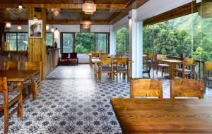 a restaurant with wooden tables and chairs and windows at Maison de Lao Chai in Sapa