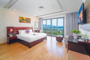 um quarto com uma cama grande e uma janela grande em Alani Hotel & Spa em Da Nang
