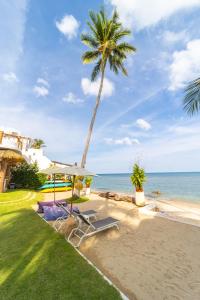a house with a palm tree and a beach at The Rock Samui - formerly known as The Rock Residence - SHA Extra Plus in Lamai