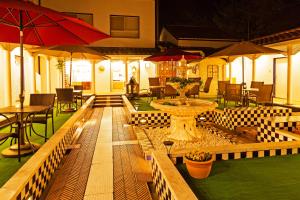 een restaurant met een tafel, stoelen en parasols bij Villa Ortigia in Minamiawaji