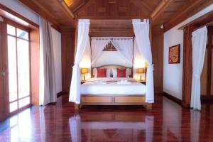 une chambre avec un lit blanc avec des oreillers rouges dans l'établissement Classic Thai style Cozy Villa fancy pool+garden, à Patong Beach 20 autres photos