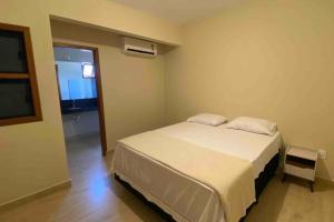 - une chambre avec un lit blanc et une fenêtre dans l'établissement Casa 5 - Vila Francisco, à Pirenópolis