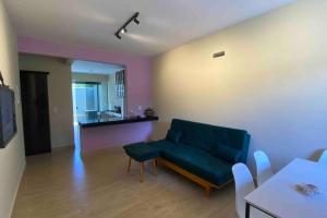 Casa 5 - Vila Francisco في بيرينوبوليس: غرفة معيشة مع أريكة زرقاء ومطبخ