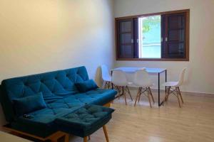 uma sala de estar com um sofá azul e uma mesa em Casa 5 - Vila Francisco em Pirenópolis