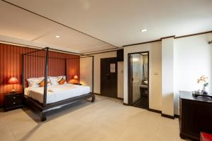 1 dormitorio con 1 cama grande y baño en Na Thapae Chiangmai Hotel en Chiang Mai