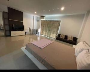 a bedroom with a large bed and a living room at BKK TEAK Hostel in Amphoe Phra Khanong
