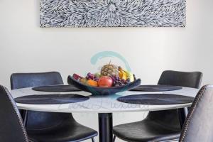 a table with a bowl of fruit on top of it at Zen by the Coast: 2-BR Cozy Retreat Near Uni/Shops in Casuarina +23 photos