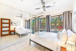 a bedroom with a bed and a balcony at Zen by the Coast: 2-BR Cozy Retreat Near Uni/Shops in Casuarina