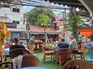 a group of people sitting in chairs at a restaurant at Orchid Residence in Patong Beach